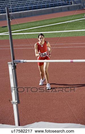 Stock Photo - Female athlete high-jumping. Fotosearch