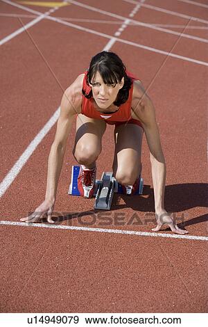 Female athlete in starting block, ready to run View Large Photo Image Stock Photo - Female athlete in starting block, ready to run. Fotosearch