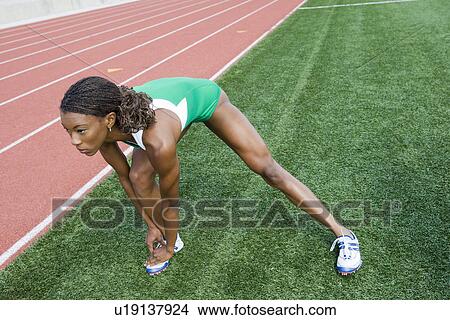 Picture - Female athlete stretching. Fotosearch
