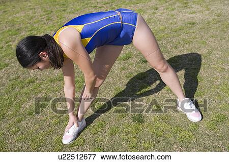 Stock Photo - Female athlete stretching. Fotosearch