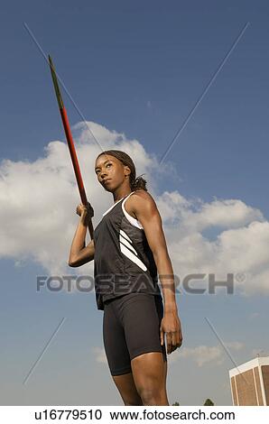 Stock Image - Female athlete throwing javelin. Fotosearch