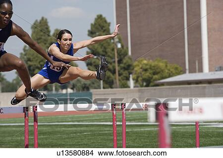 Picture - Female athletes hurdling. Fotosearch