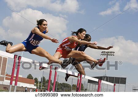 Stock Photo - Female athletes hurdling. Fotosearch