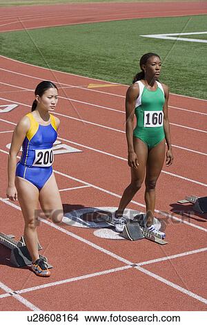 Female athletes next to starting blocks, ready to run View Large Photo Image Picture - Female athletes next to starting blocks, ready to run. Fotosearch
