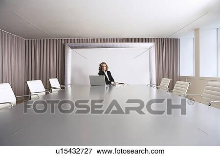 Stock Photo - Female Business Executive Sitting in Boardroom with Laptop. Fotosearch