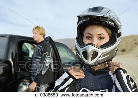 Female motocross racer fastening helmet View Large Photo Image Stock Image - Female motocross racer fastening helmet. Fotosearch