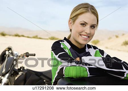 Female motocross racer in desert, smiling, (portrait) View Large Photo Image Stock Photo - Female motocross racer in desert, smiling, (portrait). Fotosearch