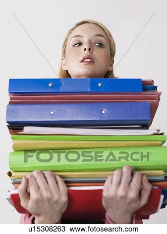Female office worker carrying heavy binders, close-up View Large Photo Image Stock Image - Female office worker carrying heavy binders, close-up. Fotosearch
