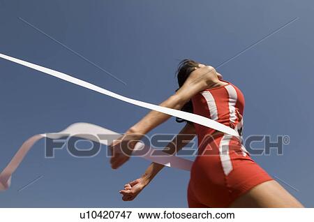 Female track athlete crossing finishing line View Large Photo Image Stock Photo - Female track athlete crossing finishing line. Fotosearch