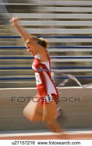 Female track athlete crossing finishing line View Large Photo Image Stock Photograph - Female track athlete crossing finishing line. Fotosearch