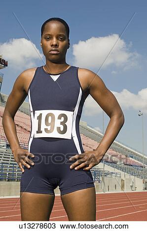 Stock Image - Female track athlete standing on track. Fotosearch