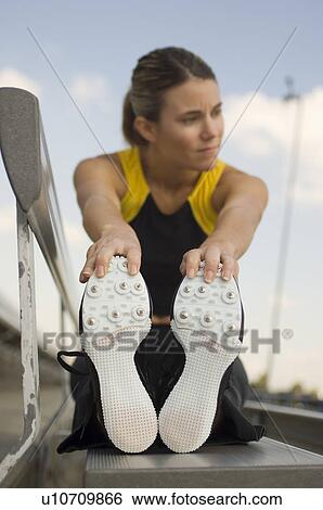 Female track athlete stretching View Large Photo Image Stock Photograph - Female track athlete stretching. Fotosearch