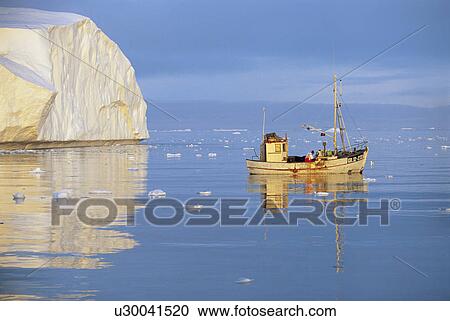 Stock Image - Fishing Boat on Ocean by Iceberg. Fotosearch