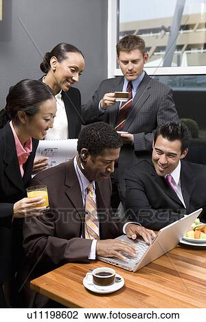Five business people using laptop in office meeting View Large Photo Image Stock Image - Five business people using laptop in office meeting. Fotosearch