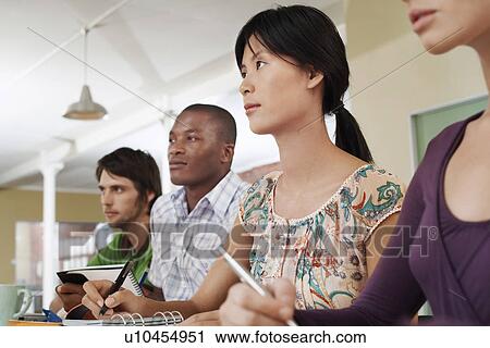 Four people sitting and taking notes. View Large Photo Image Stock Image - Four people sitting and taking notes.. Fotosearch