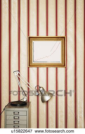 Framed graph on wall, lamp on file cabinet in office View Large Photo Image Stock Photo - Framed graph on wall, lamp on file cabinet in office. Fotosearch
