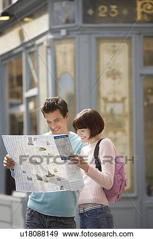 Stock Photo - France, Paris, Couple reading map on street corner. Fotosearch