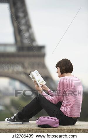 France, Paris, Young woman reading book on balcony in front of Eiffel Tower View Large Photo Image Stock Photo - France, Paris, Young woman reading book on balcony in front of Eiffel Tower. Fotosearch