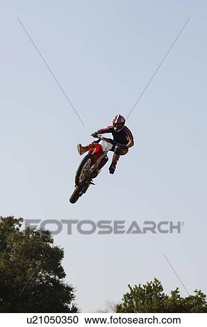 Freestyle motocross racer performing stunt in air View Large Photo Image Stock Image - Freestyle motocross racer performing stunt in air. Fotosearch