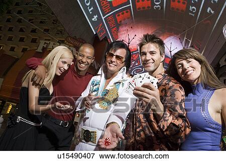 Stock Photo - Friends and Elvis impersonator having fun. Fotosearch