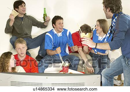 Picture - Friends watching TV and celebrating. Fotosearch