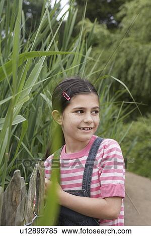 Girl (5-6) standing beside reeds View Large Photo Image Stock Photography - Girl (5-6) standing beside reeds. Fotosearch