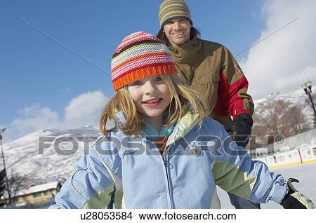 Girl (5-6) with Father at Ice Rink, front view. View Large Photo Image Picture - Girl (5-6) with Father at Ice Rink, front view.. Fotosearch