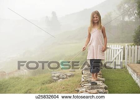 Girl Balancing with Butterfly Net on Wall View Large Photo Image Picture - Girl Balancing with Butterfly Net on Wall. Fotosearch