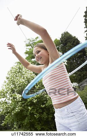Stock Photography - Girl in backyard playing with hula hoop. Fotosearch