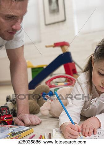 Stock Photograph - Girl on Floor Coloring With Father. Fotosearch