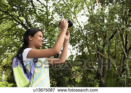 Stock Photo - Girl Photographing in Forest. Fotosearch