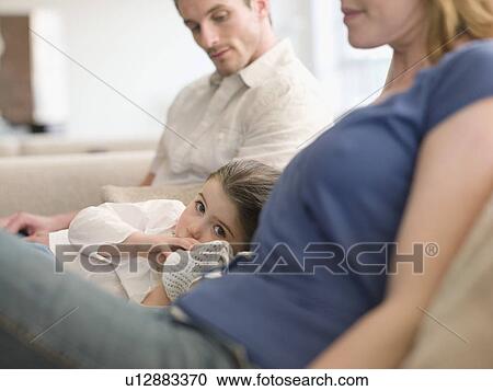 Girl Resting on Sofa Between Parents View Large Photo Image Stock Image - Girl Resting on Sofa Between Parents. Fotosearch