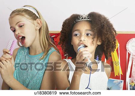 Girls using brushes, microphones to sing at a Slumber Party View Large Photo Image Stock Photo - Girls using brushes, microphones to sing at a Slumber Party. Fotosearch