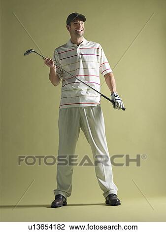Golfer standing holding club View Large Photo Image Stock Image - Golfer standing holding club. Fotosearch