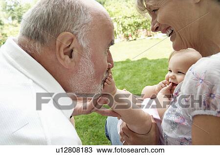 Grandparents playing with granddaughter in garden View Large Photo Image Stock Image - Grandparents playing with granddaughter in garden. Fotosearch