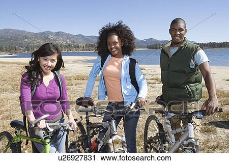 Group of fiends stand at lakeside with mountain bikes View Large Photo Image Stock Image - Group of fiends stand at lakeside with mountain bikes. Fotosearch