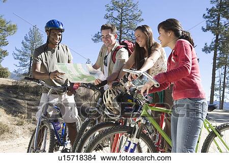 Group of friends stand with mountain bikes looking at map View Large Photo Image Picture - Group of friends stand with mountain bikes looking at map. Fotosearch