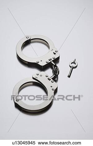 Handcuffs and key on white background in studio View Large Photo Image Stock Photography - Handcuffs and key on white background in studio. Fotosearch