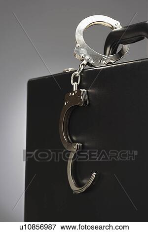 Handcuffs attached to briefcase in studio View Large Photo Image Stock Photo - Handcuffs attached to briefcase in studio. Fotosearch