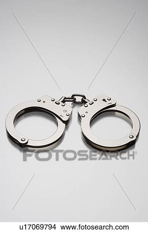 Handcuffs on white background in studio View Large Photo Image Picture - Handcuffs on white background in studio. Fotosearch