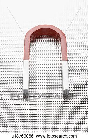 Stock Photograph - Horseshoe magnet on metallic surface. Fotosearch