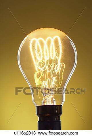 Illuminated light bulb against yellow background in studio View Large Photo Image Stock Image - Illuminated light bulb against yellow background in studio. Fotosearch