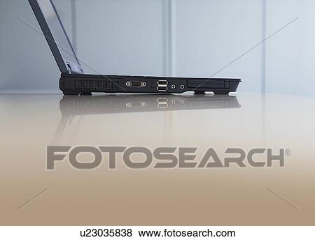 Stock Photo - Laptop on desk, side view. Fotosearch