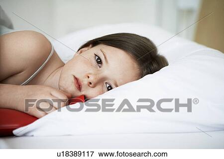 Little girl with cold in bed holding hot water bottle, portrait, close up View Large Photo Image Stock Photo - Little girl with cold in bed holding hot water bottle, portrait, close up. Fotosearch