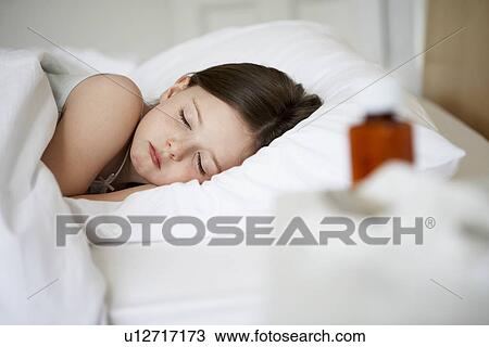Stock Image - Little with cold in bed sleeping, close up. Fotosearch