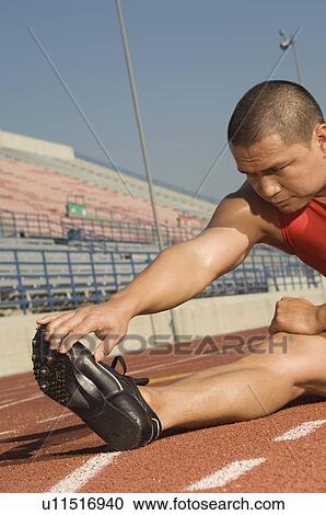 Male athlete stretching on track View Large Photo Image Stock Image - Male athlete stretching on track. Fotosearch
