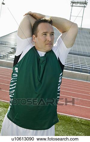 Stock Image - Male athlete stretching. Fotosearch