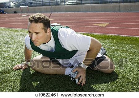 Male athlete stretching View Large Photo Image Stock Image - Male athlete stretching. Fotosearch