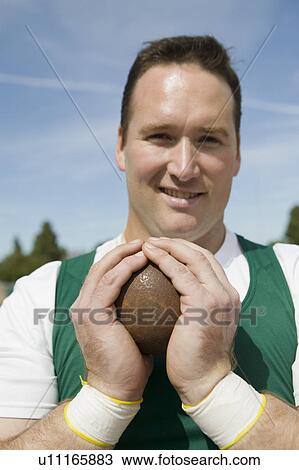 Stock Image - Male shot putter gripping shot, portrait. Fotosearch