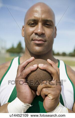 Stock Photo - Male shot putter gripping shot, portrait. Fotosearch